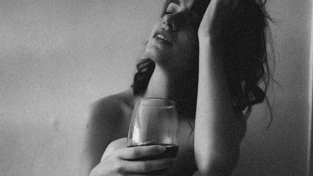 une femme mature et sexy avec un verre de vin